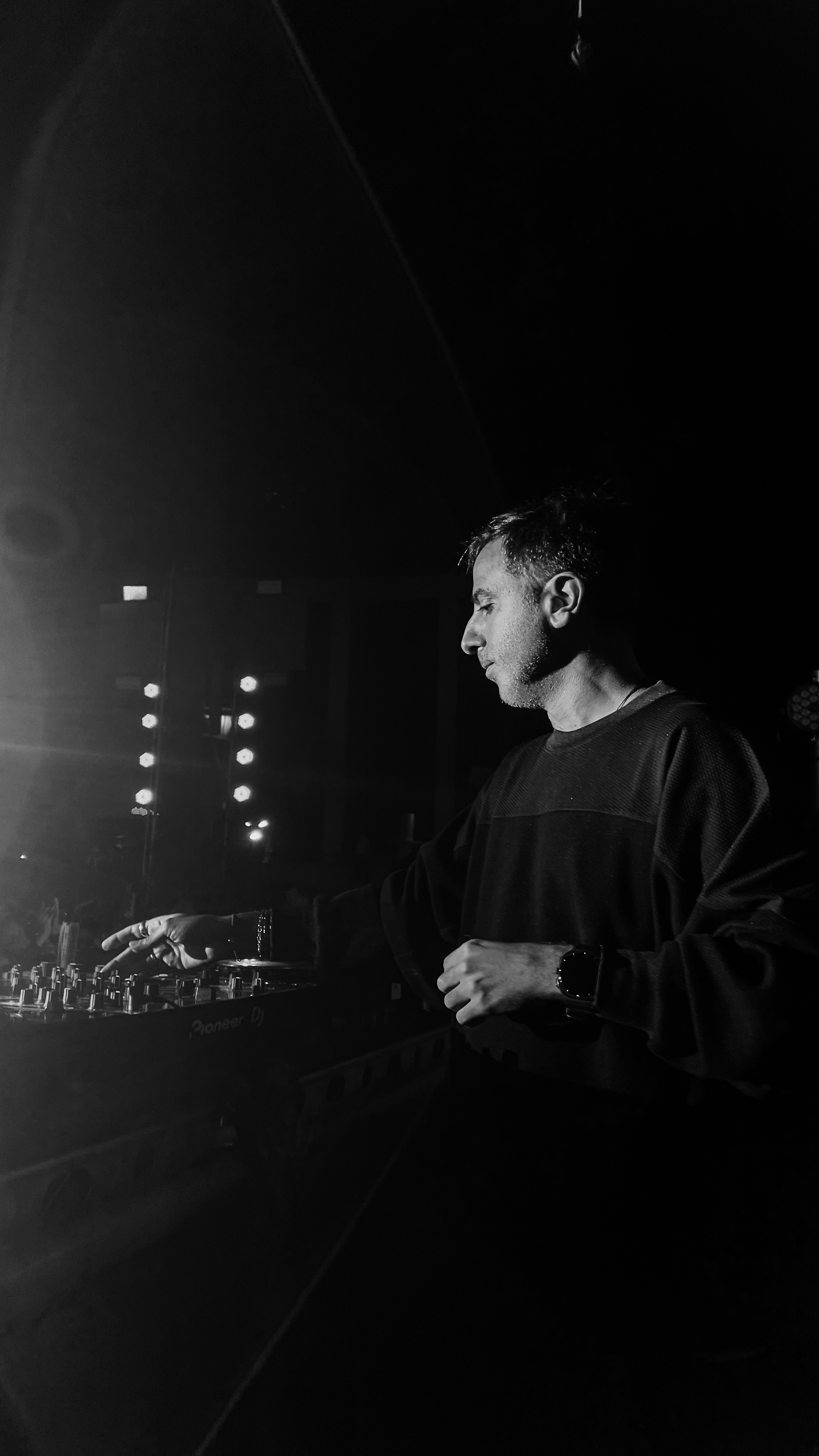 DJ tocando en un escenario con iluminación en blanco y negro